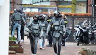 Members of the DSI special police forces patrol outside a cafe where several people are taken hostages in Ede, on March 30, 2024. (Photo by Remko de Waal / ANP / AFP)