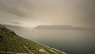 This photograph taken on March 30, 2024, shows thick sand dust blown in from the Sahara giving the sky a yellowish appearance above the vineyard terraces of Lavaux, on the banks of Lake Geneva, near Chexbres western Swizterland. (Photo by Fabrice Coffrini / AFP)