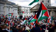 Pro-Palestinian activists and supporters wave flags as they gather for a protest in Trafalgar Square in central London on March 30, 2024, calling for a ceasefire in Gaza. (Photo by Benjamin Cremel / AFP)