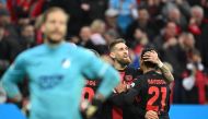 Bayer Leverkusen's German midfielder #08 Robert Andrich (C) is celebrated after scoring the equalizing 1-1 goal during the German first division Bundesliga football match Bayer 04 Leverkusen v TSG 1899 Hoffenheim in Leverkusen, western Germany on March 30, 2024. (Photo by INA FASSBENDER / AFP)
