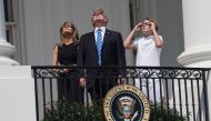 File: US President Donald Trump, First Lady Melania Trump and son Barron look up at the partial solar eclipse from the balcony of the White House in Washington, DC, on August 21, 2017. (Photo by Nicholas Kamm / AFP)