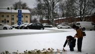 People put candles and flowers at a makeshift memorial in front of the Viertola School in Vantaa, in the north of the Finnish capital Helsinki, on April 3, 2024, one day after a 12-year-old opened fire inside the school, killing a classmate and seriously injuring two other children. Photo by Olivier MORIN / AFP