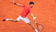 Serbia's Novak Djokovic plays a backhand return to Russia's Roman Safiullin during their Monte Carlo ATP Masters Series Tournament round of 32 tennis match on the Rainier III court at the Monte Carlo Country Club on April 9, 2024. (Photo by Valery HACHE / AFP)