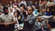 Double murder defendent OJ Simpson, looks at a new pair of Aris extra-large gloves which the prosecutors had him put on for the jury on June 21, 1995 during the OJ Simpson double murder trial in Los Angeles. (Photo by Vince Bucci / AFP)