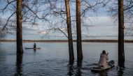 People sail on paddleboards in floodwater from the overflowing Nerl River outside the settlement of Bogolyubovo in the Vladimir region on April 13, 2024. Photo by Valery MELNIKOV / AFP