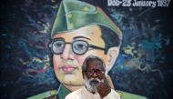 Jaganadhan, a 62-old-year man, poses for a picure in front of a mural Indian revolutionary Subhas Chandra Bose as he shows his inked finger after casting his ballot during the second phase of voting in India's general election, in Bengaluru on April 26, 2024. Photo by Idrees MOHAMMED / AFP