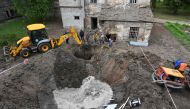 Utility workers operate next to a crater in the courtyard of a hospital in Kharkiv on April 27, 2024, as Russia launched a 