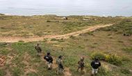 Aerial view showing Mexican marines and National Guard officers standing guard as rescue workers, forensics, and prosecutors work in a waterhole where human remains were found near La Bocana Beach, Santo Tomas delegation in Ensenada, Baja California State, Mexico, on May 3, 2024. (Photo by Guillermo Arias / AFP)
