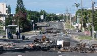 A street blocked by debris and burnt out items is seen following overnight unrest in the Magenta district of Noumea, France's Pacific territory of New Caledonia, on May 18, 2024. (Photo by Delphine Mayeur / AFP)
