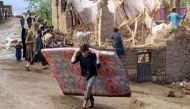 Afghan residents clean debris and salvage their belongings after flash floods following heavy rainfall at a damaged house in Firozkoh, Ghor province on May 18, 2024. Photo by AFP