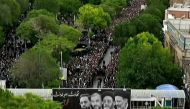 This grab taken from handout video footage released by Iran Press on May 21, 2024 shows people gathering to mourn during a funeral procession in the northwestern city of Tabriz, the capital of East Azerbaijan province. (Photo by Iran Press / AFP) 