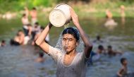 Boys bathe in the waters of Rawal dam on a hot summer day in Islamabad on May 23, 2024. The Pakistan Meteorological Department said temperatures are expected to hit as high as 50 degrees Celsius (122 degrees Fahrenheit) in parts of rural Sindh. Photo by FAROOQ NAEEM / AFP.