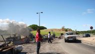 People man a roadblock barricade, with Kanak flags, controlling access to a district in Noumea, France's Pacific territory of New Caledonia, on May 24, 2024. (Photo by Theo Rouby / AFP)