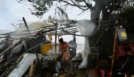 A woman stands next to her damaged house after Cyclone Remal made landfall near a beach in Kuakata on May 27, 2024. (Photo by Munir Uz Zaman / AFP)
