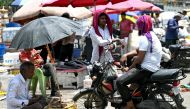 Men cover their head with cloth on a hot summer afternoon in New Delhi on May 29, 2024, amid ongoing heatwave. (Photo by Arun Sankar / AFP)