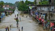 Residents wade through a flooded street after heavy rainfall in Kaduwela on the outskirts of Colombo on June 3, 2024. (Photo by Ishara S. Kodikara / AFP)

