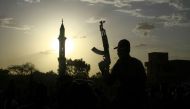 File: A fighter loyal to Sudan's army chief Abdel Fattah al-Burhan holds up a weapon backdropped by the minaret of a mosque, during a graduation ceremony in the southeastern Gedaref state on May 27, 2024. (Photo by AFP)