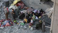 Palestinians sit on the rubble during search operations following overnight Israeli strikes in al-Bureij refugee camp in the central Gaza Strip, on June 18, 2024. (Photo by Bashar Taleb / AFP)