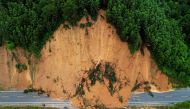 This aerial photo shows a truck driving past a landslide site after storms in Liuzhou, in southwestern China's Guangxi province on June 13, 2024. Photo by AFP.