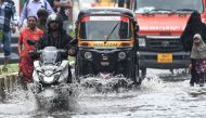 Vehicles drive through a flooded street after rain showers in Mumbai on July 8, 2024. (Photo by Punit Paranjpe / AFP)
 