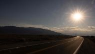 The sun sets over California Highway 190 winding across Death Valley National Park, near Furnace Creek, during a heatwave impacting Southern California on July 7, 2024. (Photo by ETIENNE LAURENT / AFP)
