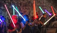 Members of the Jedi Knight Academy (JKAMX) hold light sabers during a group practice session at a park in Mexico City on July 6, 2024. (Photo by CARL DE SOUZA / AFP)
