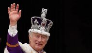 File: Britain's King Charles III wearing the Imperial state Crown, waves from the Buckingham Palace balcony after viewing the Royal Air Force fly-past in central London on May 6, 2023, after his coronation. (Photo by Stefan Rousseau / POOL / AFP)