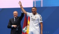 French forward Kylian Mbappe (R) waves to the fans next to Real Madrid's President Florentino Perez during a first appearance as a Real Madrid player at the Santiago Bernabeu Stadium in Madrid on July 16, 2024.  (Photo by Pierre-Philippe MARCOU / AFP)
