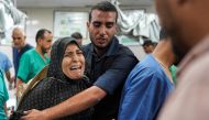 A man comforts a woman as she reacts at a trauma ward at Nasser Medical Complex in Khan Yunis in the southern Gaza Strip on July 16, 2024. (Photo by Bashar TALEB / AFP)
