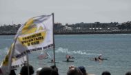 Protestors light a flare as they go in canoes off the coast, during a demonstration against the construction of giant water reservoir (mega-bassine) in La Rochelle, western France, on July 20, 2024. (Photo by Philippe Lopez / AFP)