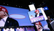 A photo showing a bullet going past US former President and 2024 Republican presidential candidate Donald Trump's head during an assassination attempt is shown on screen as he speaks onstage during the last day of the 2024 Republican National Convention at the Fiserv Forum in Milwaukee, Wisconsin, on July 18, 2024. (Photo by Brendan SMIALOWSKI / AFP)
