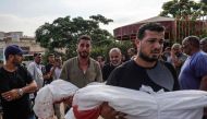 Mourners carry the bodies of members of the Qadih family to a burial ground in Khuzaa in the southern Gaza Strip, following an overnight Israeli strike that hit their house in Bani Suheila, reportedly killing two children, their father, uncle, paternal grandparents and severely injuring their mother, on July 21, 2024. (Photo by Bashar TALEB / AFP)
