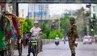 A Bangladeshi soldier stands guard along a street amid the anti-quota protests, in Dhaka on July 20, 2024. (Photo by Munir UZ ZAMAN / AFP)
