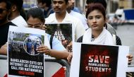 Students from Bangladesh hold placards as they demonstrate to ask the government to end the crackdown on protesters on July 22, 2024. (Photo by Filippo Monteforte / AFP)