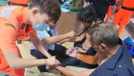 This handout picture taken on July 25, 2024 and released on July 26 by the Taiwan Coast Guard shows two Myanmar sailors being taken cared of by Taiwanese Coast Guard after their Tanzania-flagged ship sank near Kaohsiung during Typhoon Gaemi. Photo by Handout / TAIWAN COAST GUARD / AFP