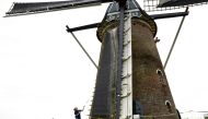 Dutch artist Peet Wessels adjusts the sails of De Heimolen, an ancient wheat mill in Rucphen-Bosschenhoofd, near the southern Dutch city of Breda. (Photo by Nick Gammon / AFP)
 