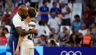 France's coach Thierry Henry (L) hugs France's midfielder #21 Johann Lepenant at the end of the Paris 2024 Olympic Games men's group A football match between New Zealand and France, at the Marseille Stadium, in Marseille, southern France, on July 30, 2024. (Photo by Clement MAHOUDEAU / AFP)
