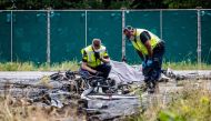 Dutch Police officers investigate the debris of a small plane after it crashed on the A58 motorway in Rucphen on July 31, 2024. Photo by Jeffrey GROENEWEG / ANP / AFP