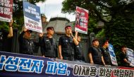 Members of the National Samsung Electronics Union (NSEU) gather during a protest outside the residence of Samsung Electronics Chairman Lee Jae-yong, while holding red placards of Lee that red 