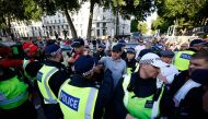A protestor remonstrates with police officers during the 'Enough is Enough' demonstration on Whitehall, outside the entrance to 10 Downing Street in central London on July 31, 2024, held in reaction the Government's response to the fatal stabbings in Southport on July 29. (Photo by BENJAMIN CREMEL / AFP)
