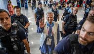 Bangladesh's finance pioneer Muhammad Yunus (centre) is escorted by French police personnel as he arrives at Roissy-Charles de Gaulle Airport, north of Paris on August 7, 2024, enroute to Bangladesh. (Photo by Luis Tato / AFP)
