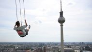 Pascal Vent sways 120m above the rooftops of Berlin, from Europe's highest swing at Alexanderplatz, on July 31, 2024. (Photo by RALF HIRSCHBERGER / AFP)