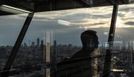 A man walks at the Bunkyo Civic Center Observation Deck as the city's skyline is seen in Tokyo on August 14, 2024. (Photo by Philip FONG / AFP)
