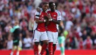 Arsenal's Dutch defender #12 Jurrien Timber (L) and Arsenal's English midfielder #07 Bukayo Saka (R) celebrate their win on the pitch after the English Premier League football match between Arsenal and Wolverhampton Wanderers at the Emirates Stadium in London on August 17, 2024. (Photo by Adrian DENNIS / AFP)
