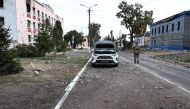 This photograph taken on 16 August, 2024, a media tour organised by Ukraine, shows a Ukrainian soldier walking on a damaged street in Ukrainian-controlled Russian town of Sudzha, Kursk region, amid the Russian invasion in Ukraine. (Photo by Yan DOBRONOSOV / AFP)
