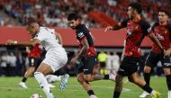 Real Madrid's French forward #09 Kylian Mbappe (L) dribbles the ball as he is challenged by Real Mallorca's Spanish midfielder #18 Antonio Sanchez (2R) during the Spanish league football match between RCD Mallorca and Real Madrid CF at the Mallorca Son Moix stadium in Palma de Mallorca on August 18, 2024. (Photo by OSCAR DEL POZO / AFP)

