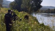 This handout photograph made available by the Ministry of Interior of Serbia shows Serbian Police officers searching a bank of the Drina River after a boat carrying 30 illegal migrants sank on the border between Serbia and Bosnia-Herzegovina near the town of Ljubovija, on August 22, 2024. (Photo by Handout / SERBIAN INTERIOR MINISTRY / AFP)