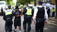 Police officers make an arrest at the Notting Hill Carnival in west London on August 26, 2024. (Photo by HENRY NICHOLLS / AFP)