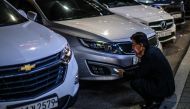 A man sits near parked cars along a road in Seoul on August 20, 2024. (Photo by ANTHONY WALLACE / AFP)
