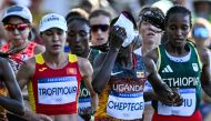 (Files) Uganda's Rebecca Cheptegei (C) applies an ice bag on her head as she competes in the women's marathon at the Paris 2024 Olympic Games in Paris on August 11, 2024. (Photo by Kirill Kudryavtsev / AFP)
 